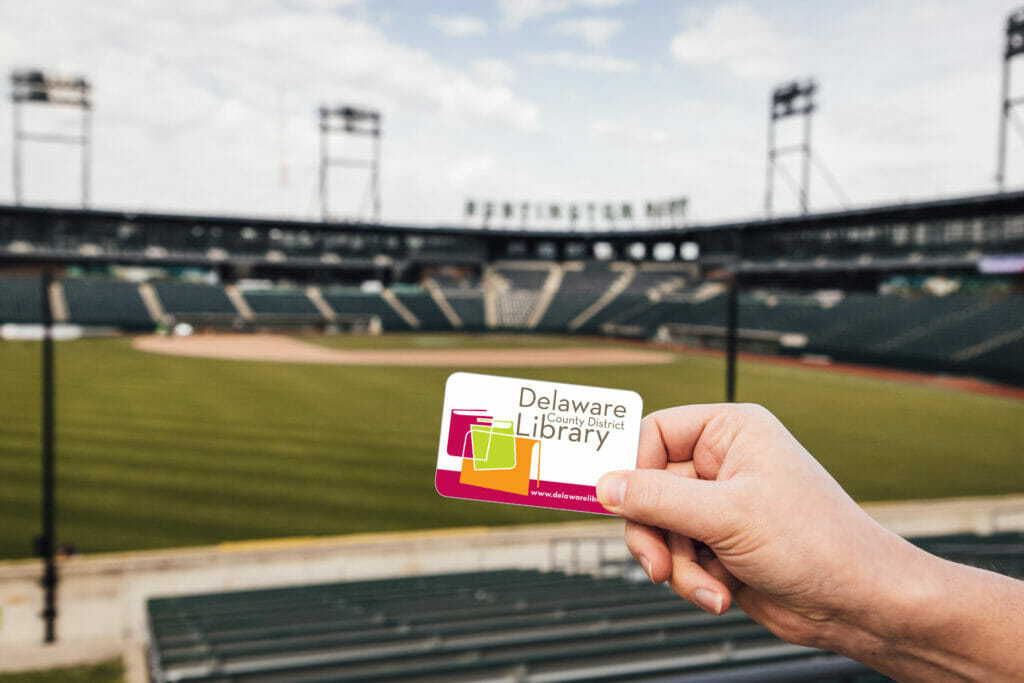 Library card held in front of Huntington Stadium, where the Columbus Clippers play