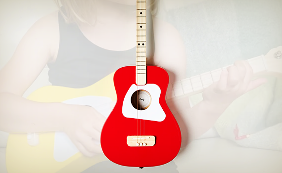 Kid holding a Loog Guitar