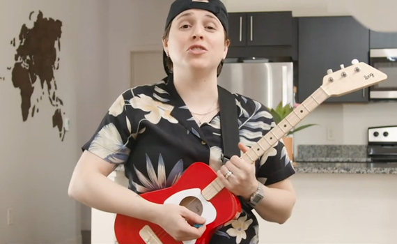 Kid holding a Loog Guitar